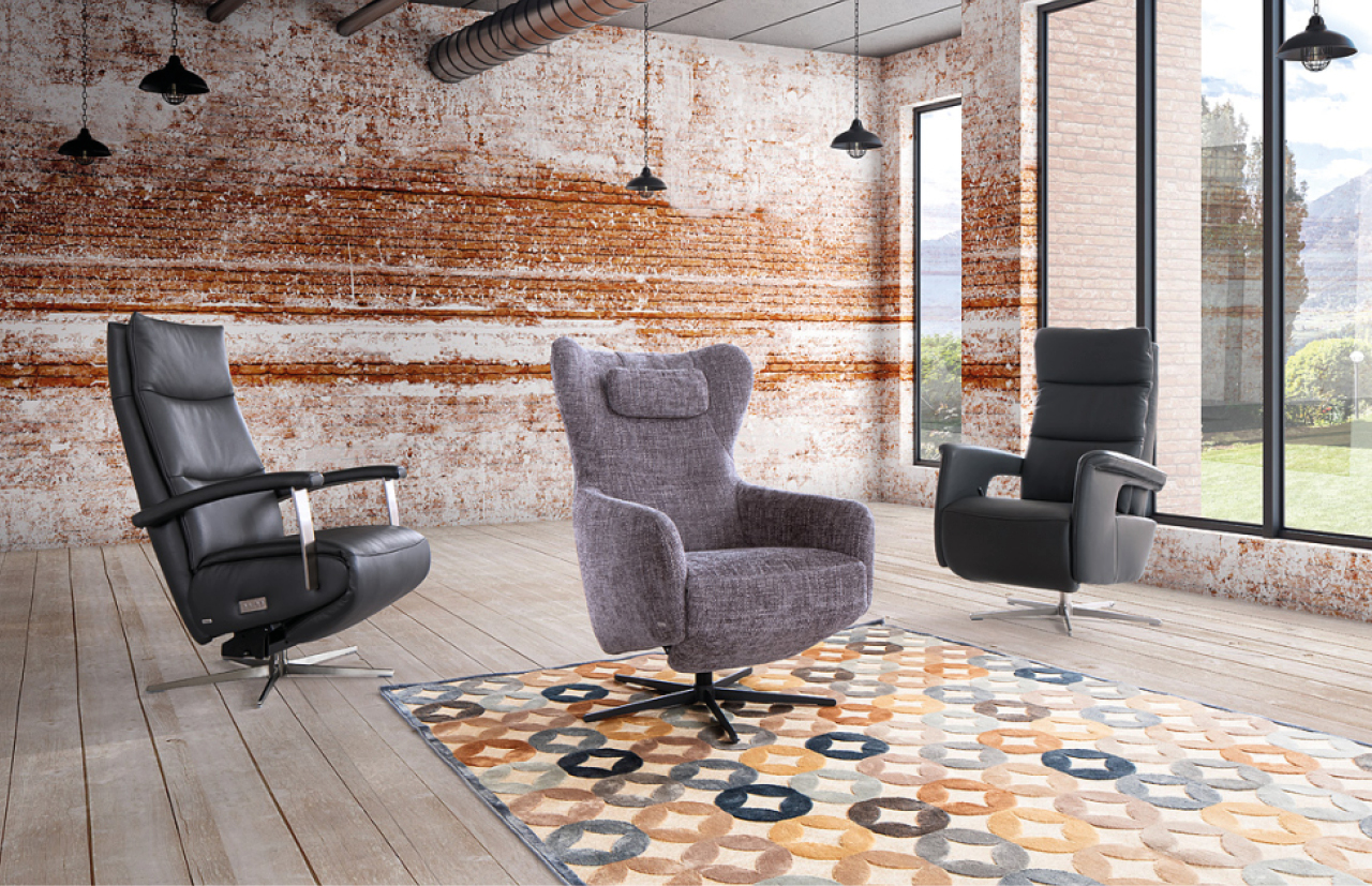 Drei verschiedene Relaxsessel mit unterschiedlichen Bezuegen in rustikalem Wohnzimmer.