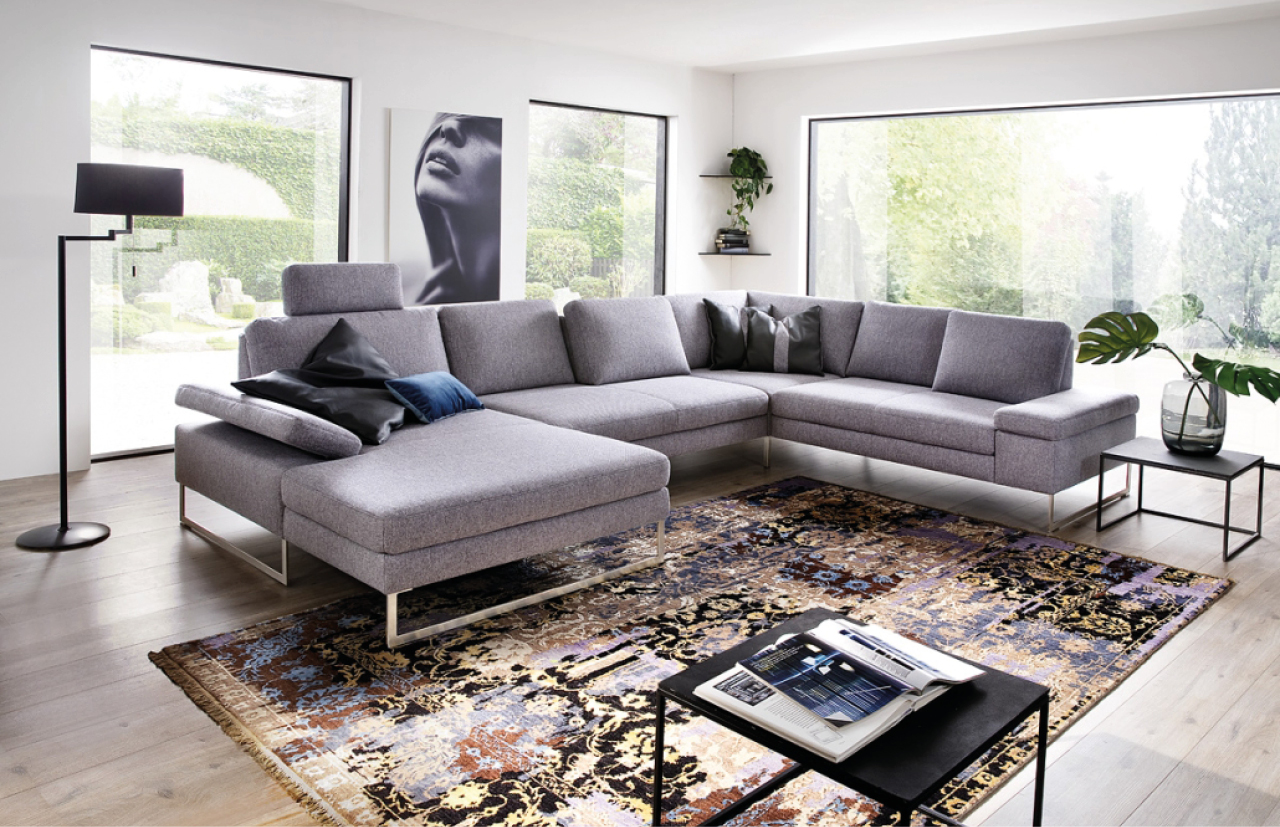 Hellgraues Stoffsofa in hellem, offenen Wohnzimmer.