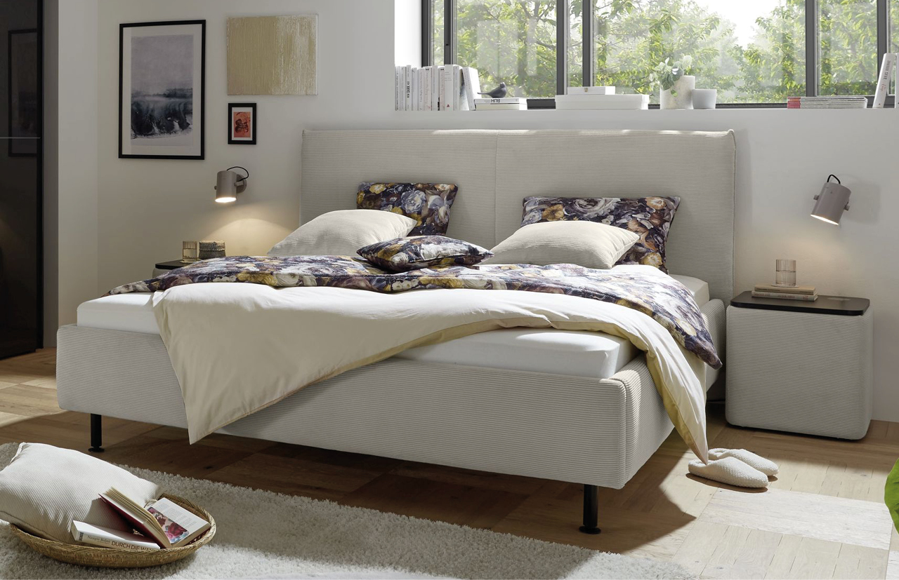 Helles Bett in gemuetlichem Schlaftimmer.