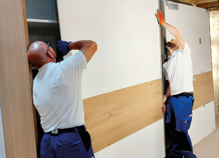 Mitarbeiter von Moebel Eickert demontieren Kleiderschrank.